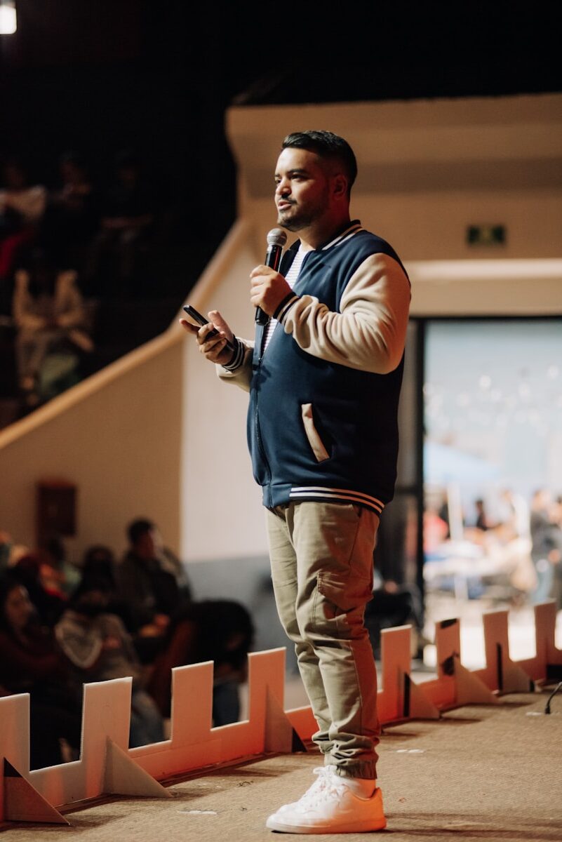 A man standing in front of a crowd holding a microphone